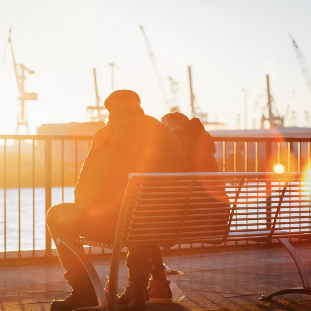 Two people sat together on a bench.