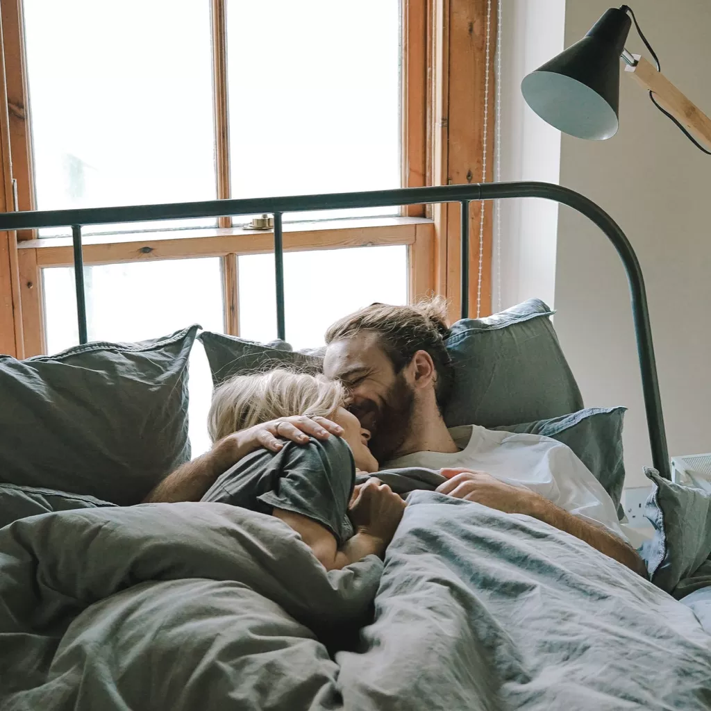 A couple having an authentic start to the day, talking in bed.