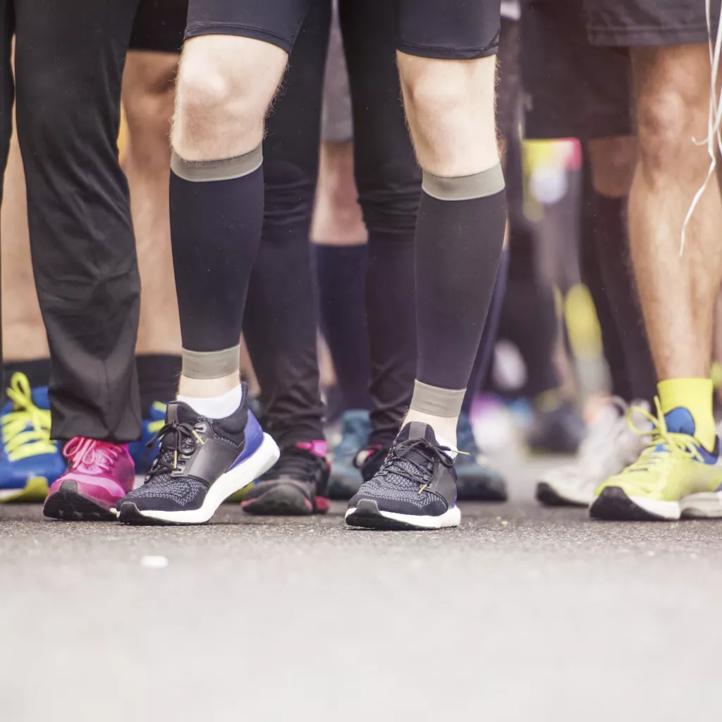 The legs of runners at the start of a race.