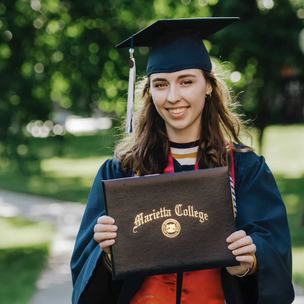 A collage graduate holding her certificate.