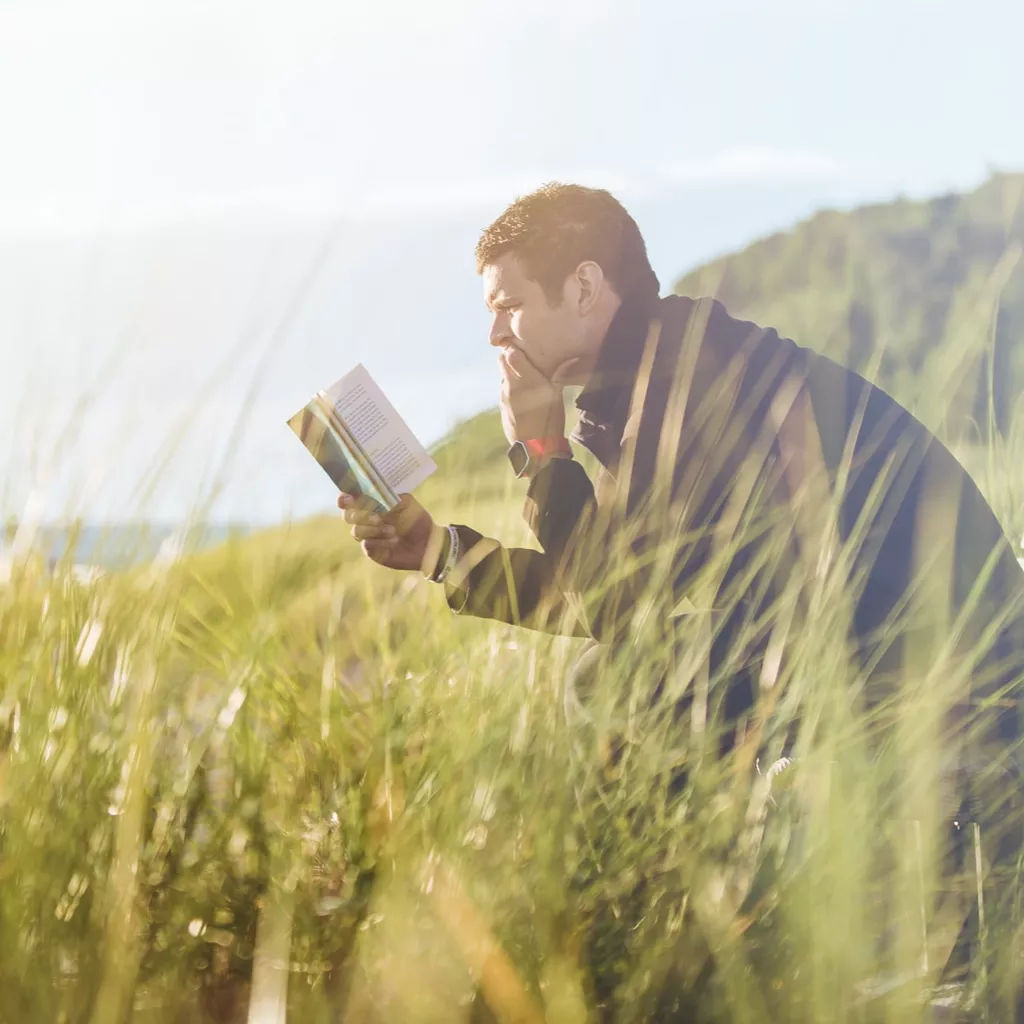 Man reading a book in nature.