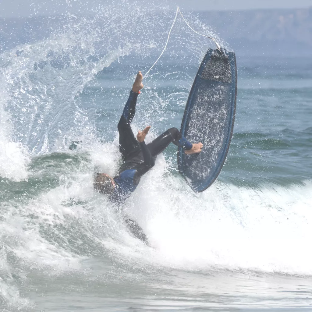 A surfer falling from his board.