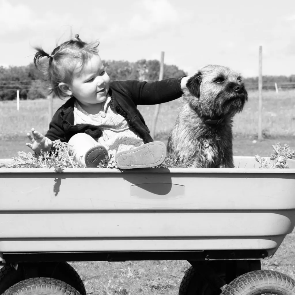 An old photo of a child with her dog.