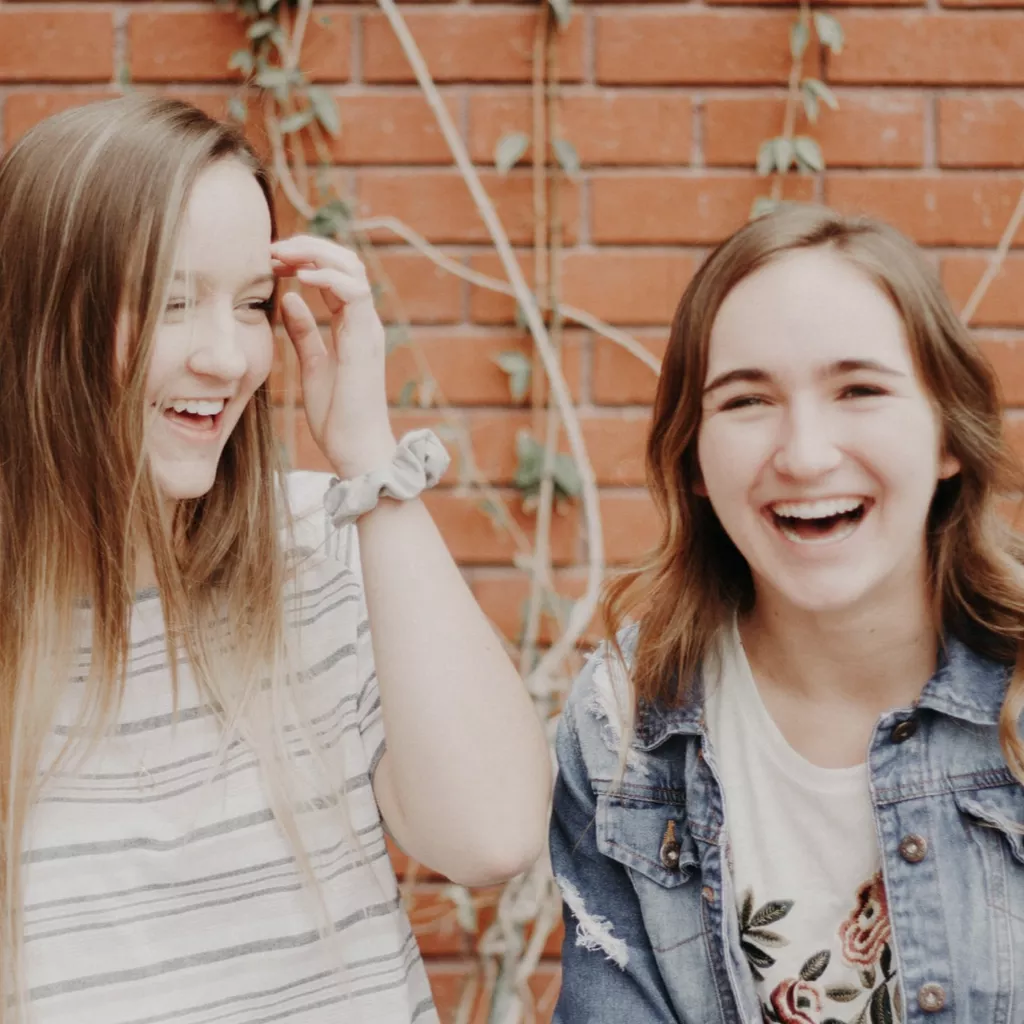 Two girls, both laughing.