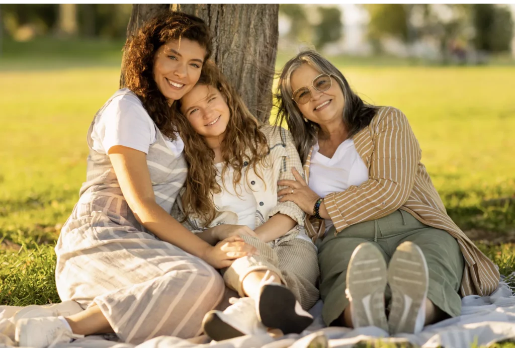 Three generations of the same family, sat together under a tree.