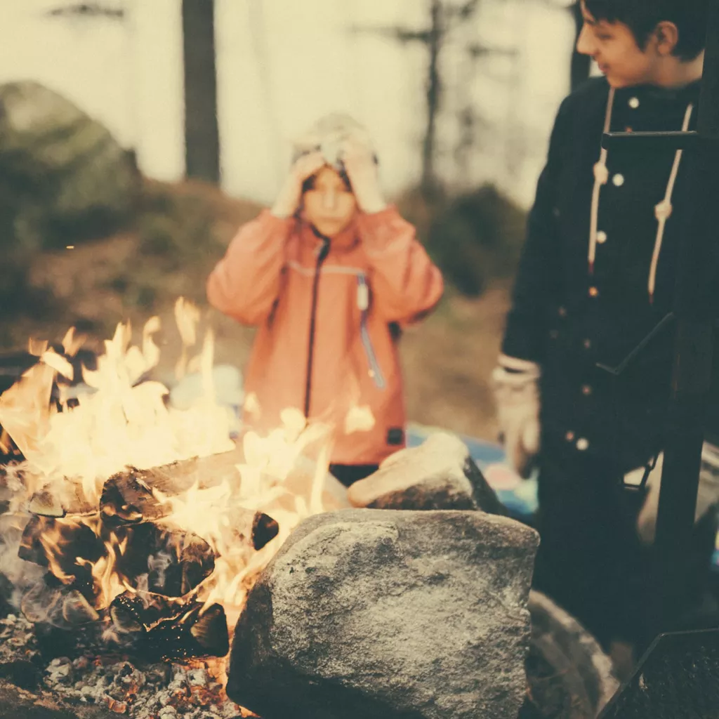 An old photo of two children by a fire.