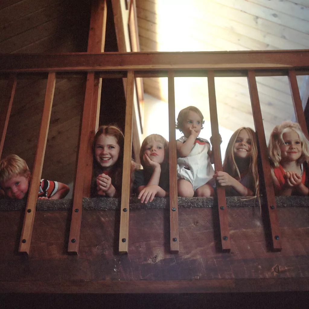 Lots of children gathered together at the top of the staircase.