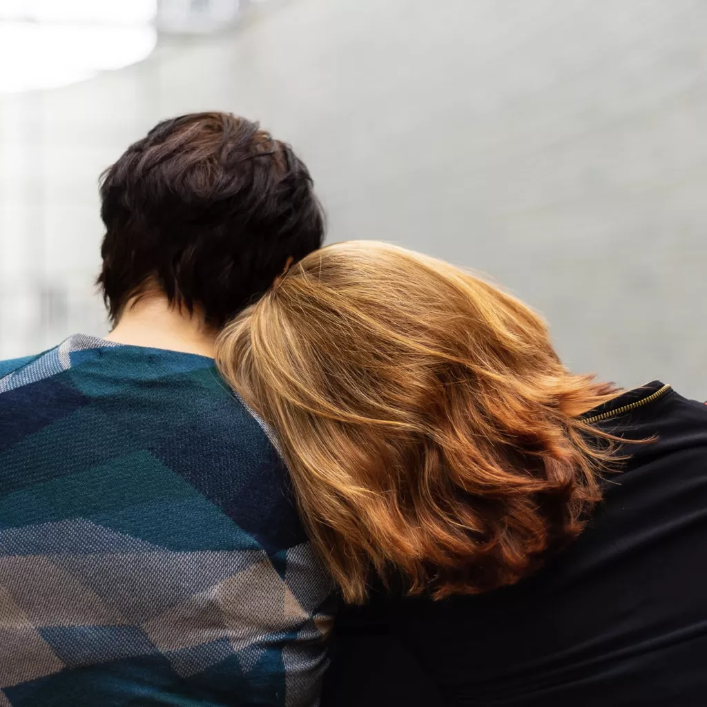 A lady's head resting on someone's shoulder.