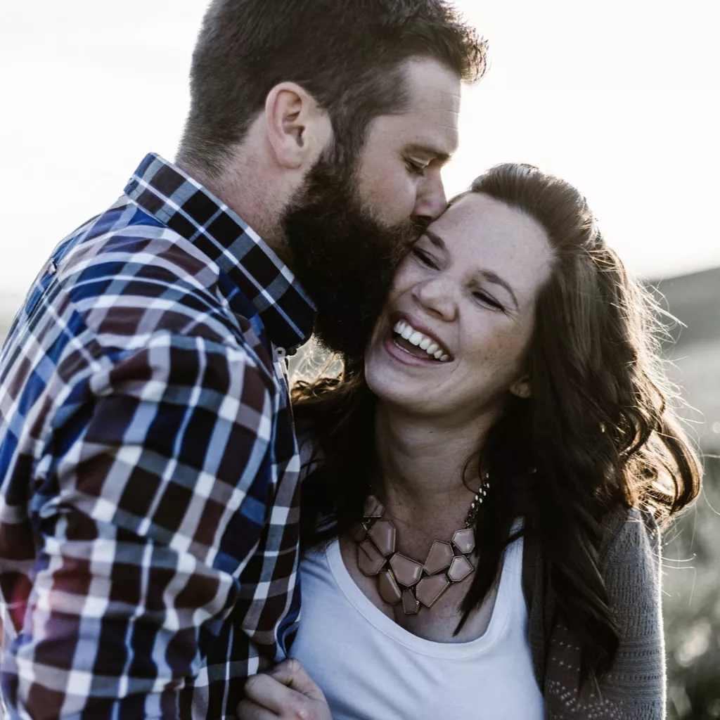 A man kissing his partner.