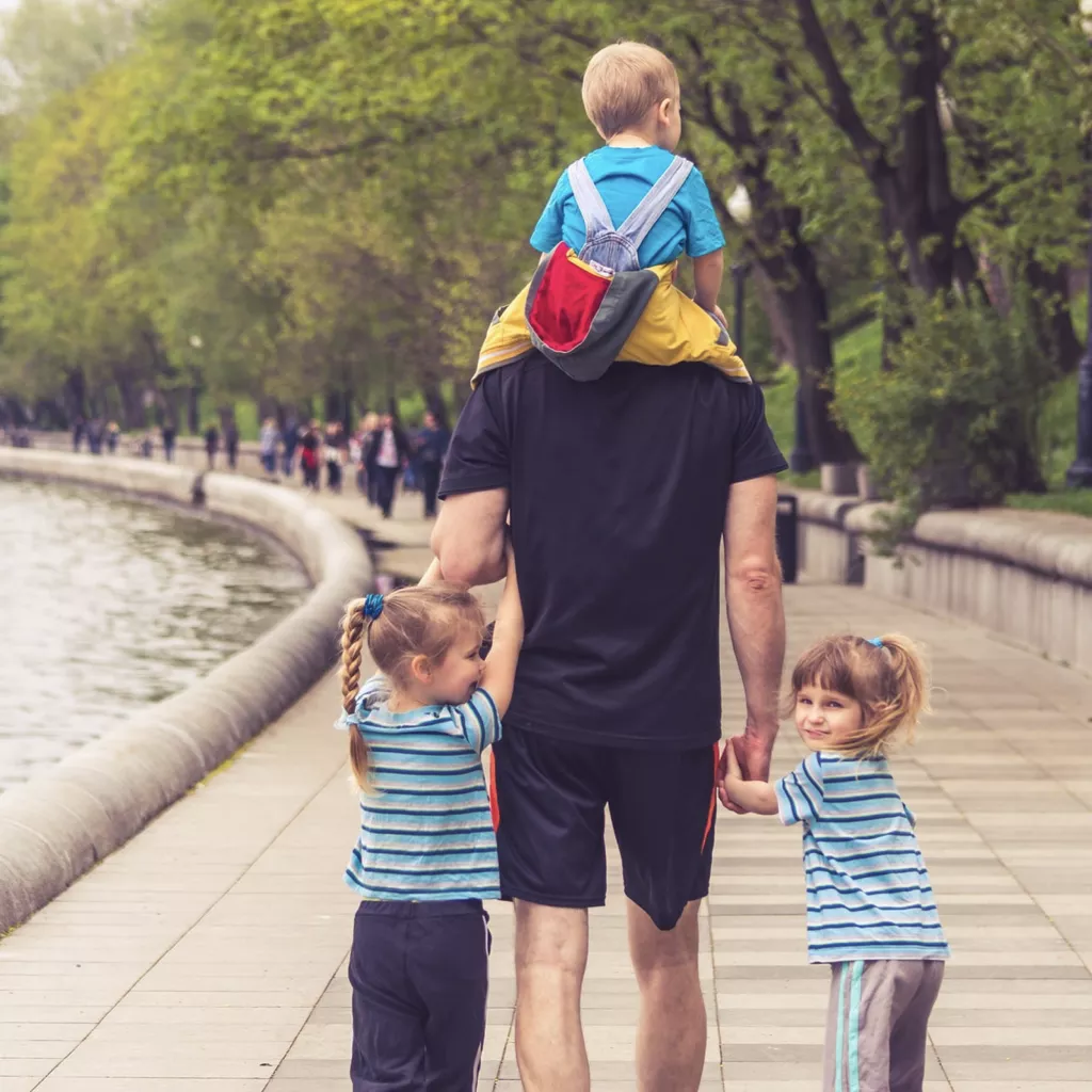 A father surrounded by three children.