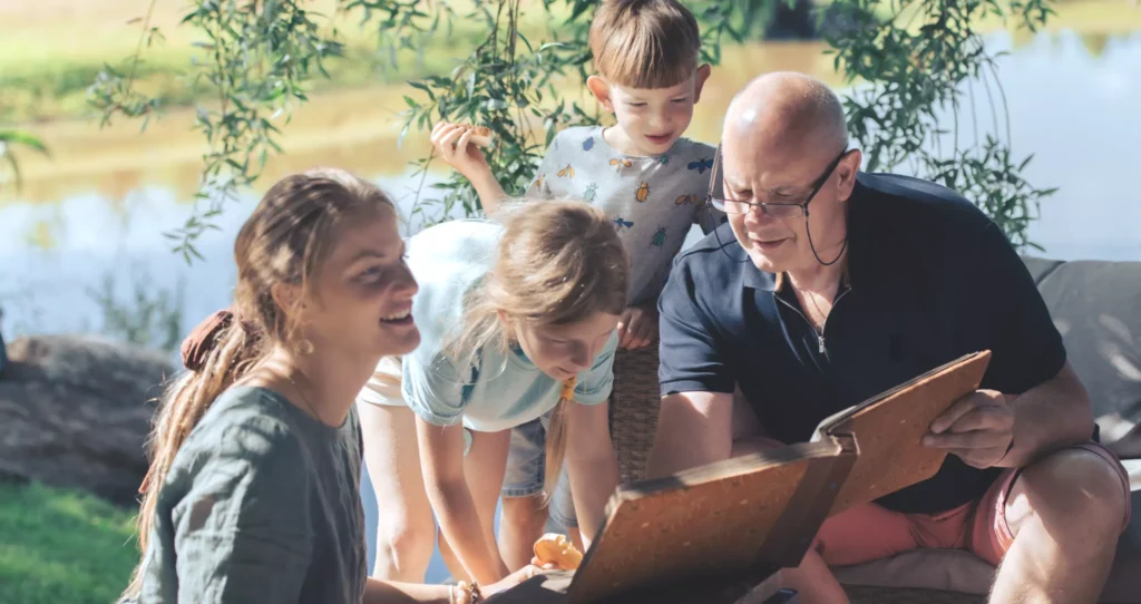 A family looking at a book of recorded family stories.