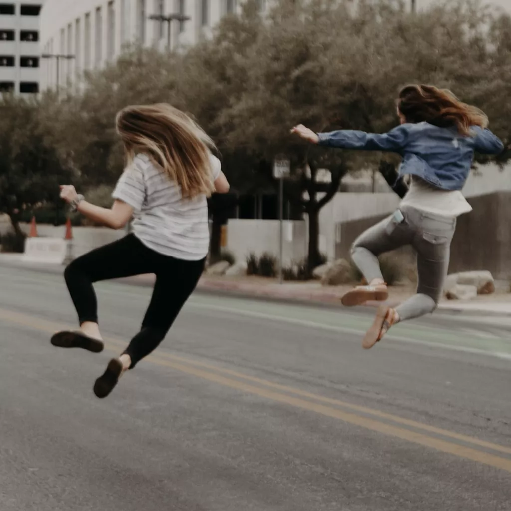 Two young girls jumping for joy.