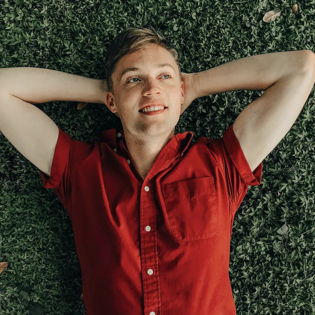 A man lying on the ground, looking proud.