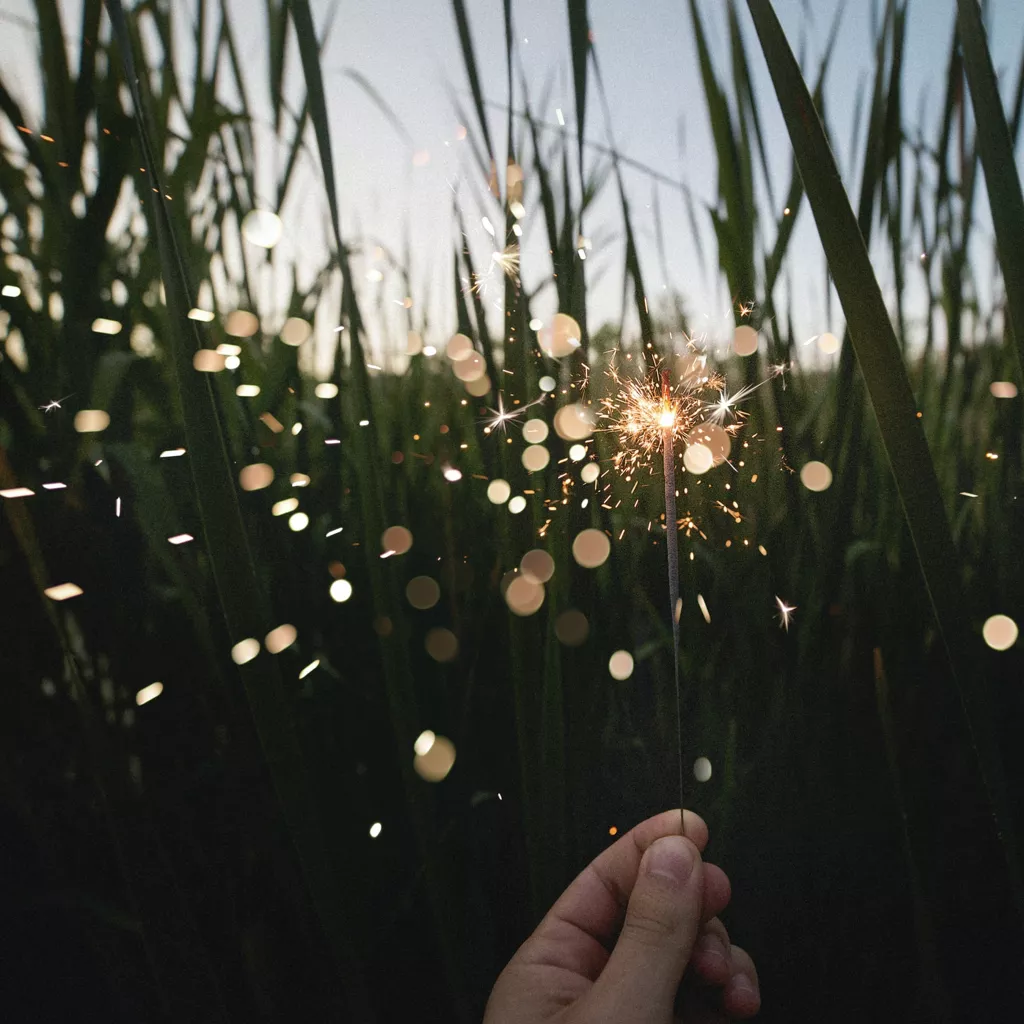 Sparks fly from a sparkler.