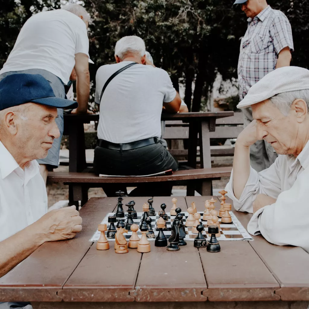 Two old men playing chess in the park.