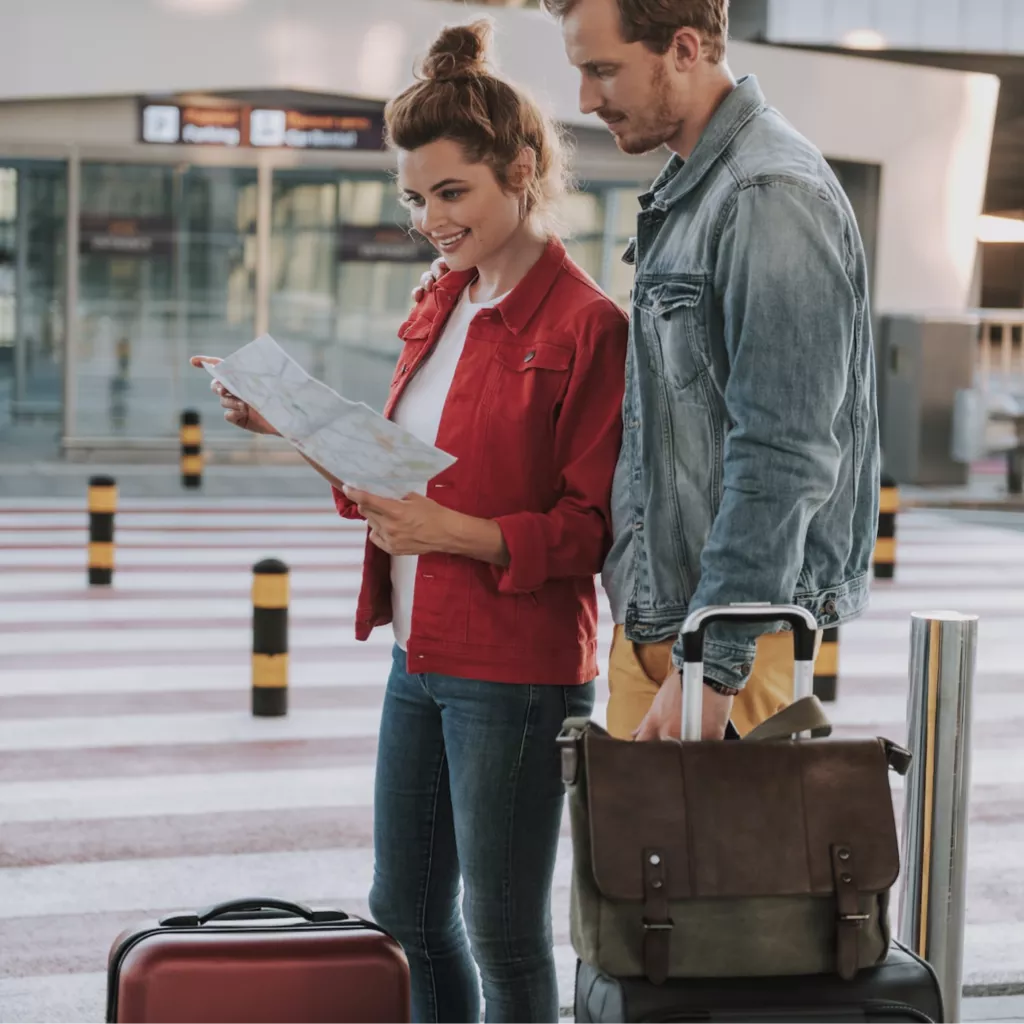 A couple with suitcases, ready to travel.