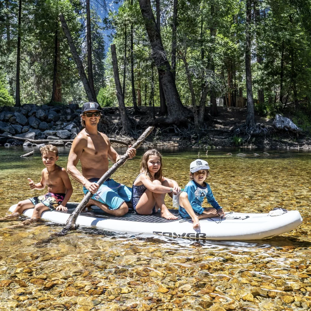 A father with three children on a paddle board.